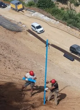 Tecnici al lavoro sull’installazione di una sonda di monitoraggio lungo il versante franoso di Rota Greca, sopra la strada.